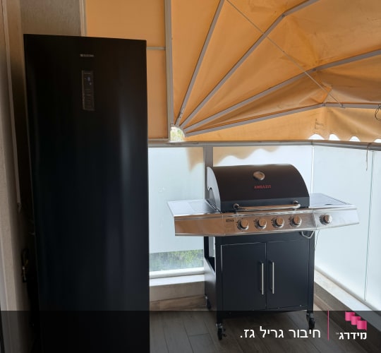 גריל גז ומקרר במרפסת עם גג כתום